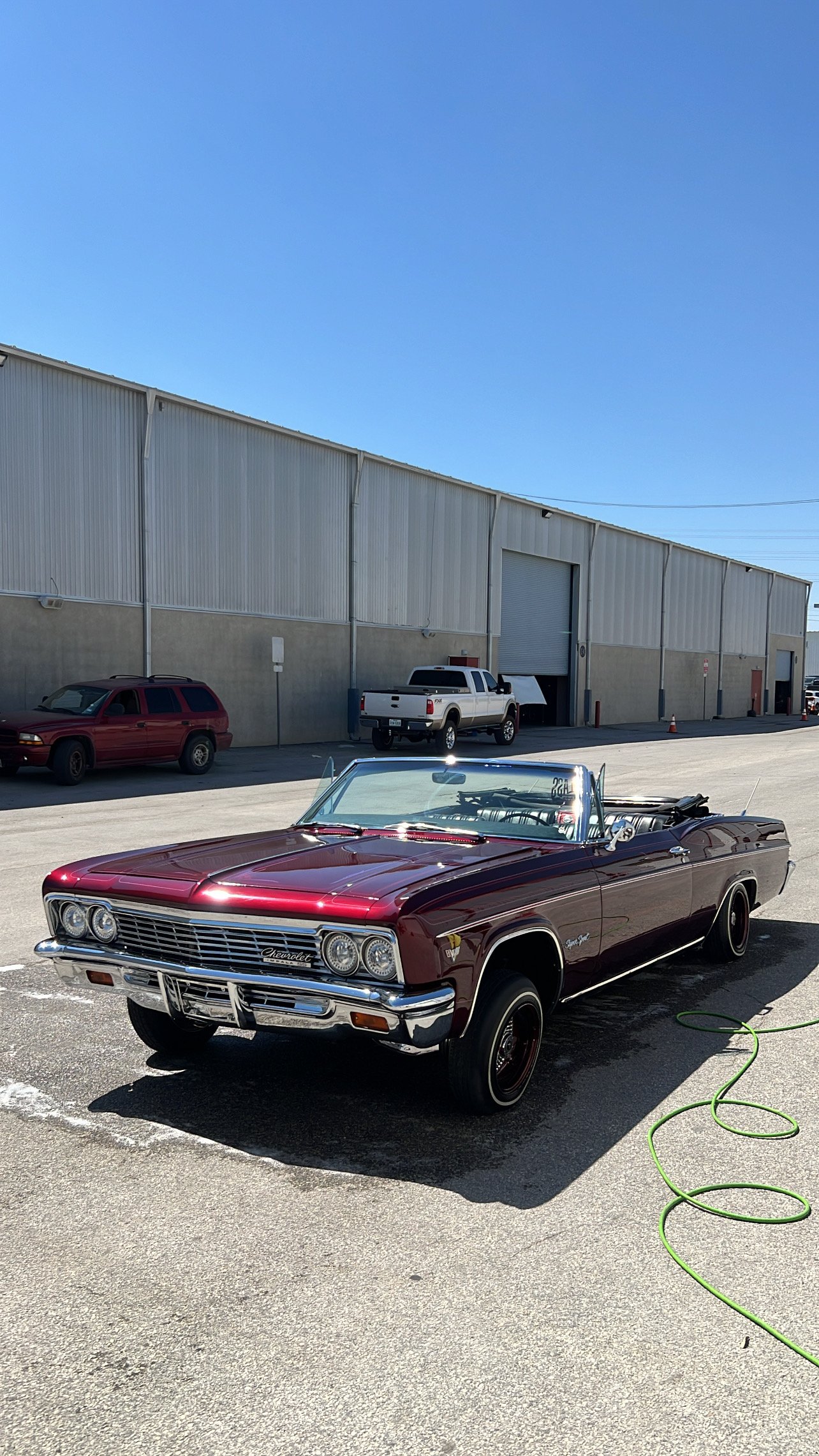 Maroon lowrider Impala convertible on display at the San Antonio Lowrider Super Show